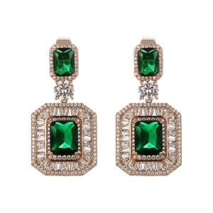 Macro detail of emerald cut green drop earrings with brilliant white zircon accents