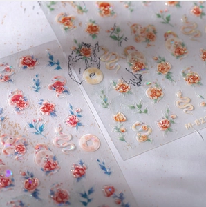 Macro shot of M-8225 nail art stickers with laser glitter roses, snakes and coins