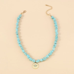 Macro view of blue turquoise beads and evil eye pendant on a gold plated necklace