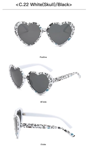 Detailed views of heart sunglasses with white frame and black skull graffiti patterns