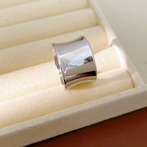 Macro shot of polished wide silver open ring placed on a beige velvet jewelry box