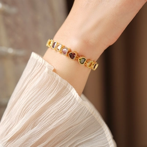 Close-up of heart-shaped multi-color gemstone bracelet with vintage gold beaded edges