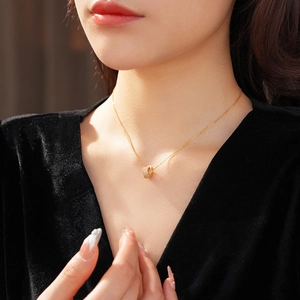 Close-up of a gold double interlocking ring necklace with pavé zircons on model