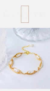 Close-up of handmade gold wire-wrapped natural pearl bracelet with adjustable chain