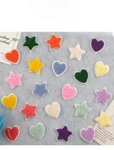 Colorful heart and star chenille patches with white borders on light blue background