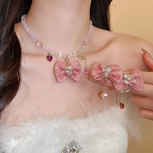 Detail of pink fabric bow necklace and matching hairpins with sparkling crystals