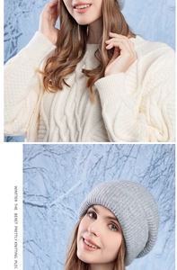 Dettaglio di un cappello in maglia grigio chiaro e un maglione bianco a trecce