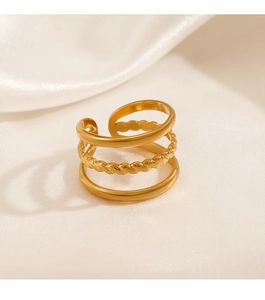 Close-up of a three-layer gold ring with twisted rope design on white silk background
