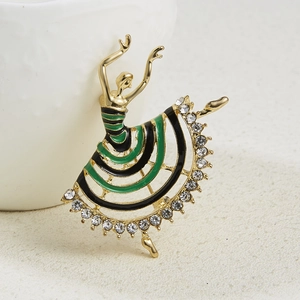 Macro detail of ballerina brooch with gold plating, green enamel, and crystal rhinestones