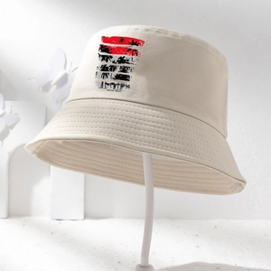 Détail du chapeau bob beige avec imprimé Sunset Beach et motif de silhouettes de palmiers