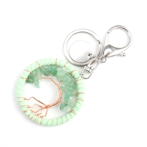 Detailed macro view of handmade tree of life keychain with green stones and copper wire