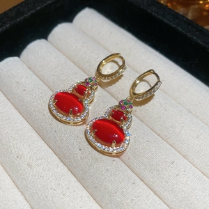 Detail of 18K gold plated gourd earrings with red gemstones and colorful crystals