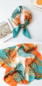 Detail of silk scarf with orange and green tree pattern, shown tied and flat on white background