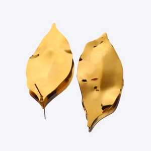 Macro detail of gold leaf stud earrings with 18k plated textured surface and push back design