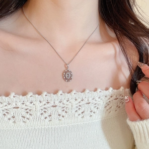 Close-up of elegant zircon oval pendant necklace on model with light blue gemstone