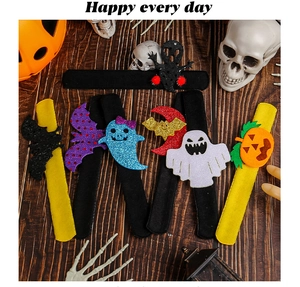 Halloween felt slap bracelets with bat ghost pumpkin designs on a rustic wood background