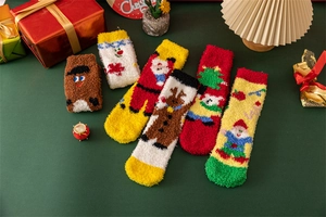 Flat lay of fuzzy Christmas coral fleece socks with festive patterns and gift box decor