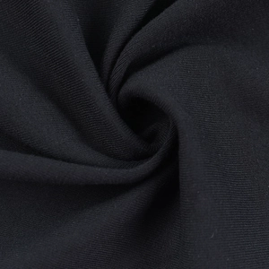 Macro detail of soft black knit fabric texture with elegant drape and fine weave patterns