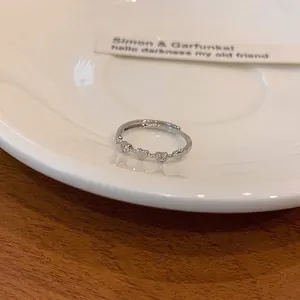 Close-up of a silver heart ring with micro-paved zircons on a white ceramic tray