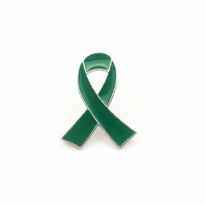 Close-up of green enamel ribbon awareness brooch with polished silver-tone metal edges