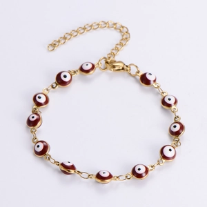 Detailed view of golden Evil Eye bracelet with burgundy enamel beads and lobster clasp