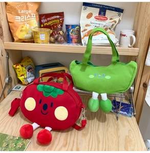 Detail of cute tomato and pea shaped canvas bags with plush legs and shoulder strap
