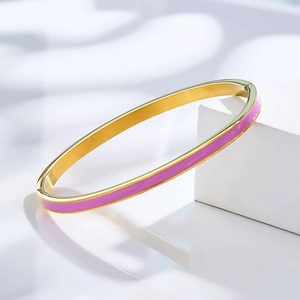 Detail of gold-plated bangle featuring purple enamel inlay and polished metal edges