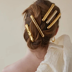 Elegant gold metal hair clips for women shown on model hair with high-shine texture