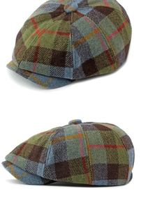 Detailed close-up of wool plaid newsboy cap with green and brown checkered pattern texture