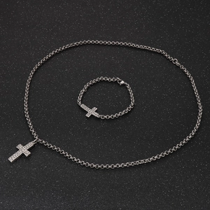 Close-up of vintage steel cross jewelry set with hammered texture on necklace and bracelet