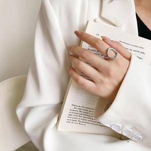 Minimalist silver stainless steel open ring shown on hand holding a vintage book