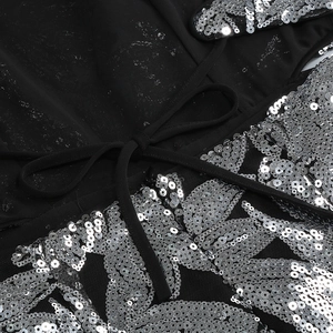 Vue macro de paillettes argentées sur tulle noir avec détails de rubans croisés