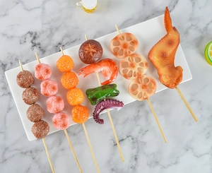Dettaglio macro di spiedini barbecue realistici con gamberi grigliati, polpette e loto