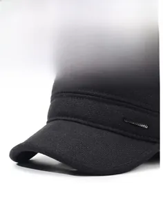 Detail of black military flat cap showing textured fabric and silver metal logo tag