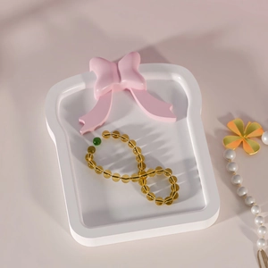 Bowknot resin silicone mold tray with amber beaded bracelet and green accent stone