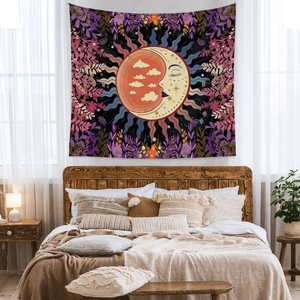 Detail of bohemian sun and moon tapestry hanging above a wooden bed in a cozy bedroom