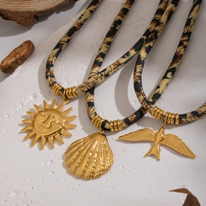 Three bohemian leopard print cloth necklaces with golden sun, shell and bird pendants