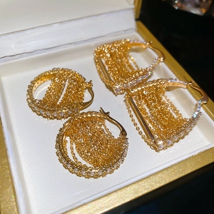 Macro detail of 18k gold plated chain earrings with sparkling zircon inlay in a jewelry box
