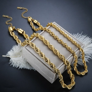 Detail of 6mm 18K gold plated rope chains layered on silk with elegant feathers