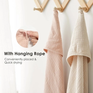 Close-up of muslin baby towel showing functional hanging rope for quick drying and storage