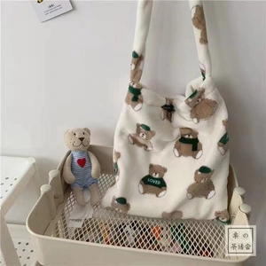 Detail of plush cow print tote bag featuring a cute brown bear pattern and soft texture