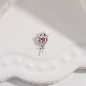 Macro shot of silver petal-shaped pendant base with a round magenta gemstone inlay
