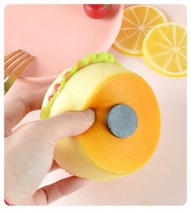 Macro shot of a squishy faux burger fridge magnet showing its soft PU foam and magnetic base