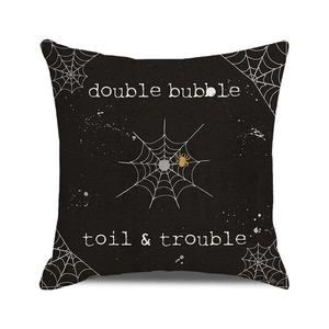 Detail of Halloween throw pillow with double bubble text and orange spider on linen texture