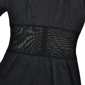 Detail of black satin dress featuring sheer mesh patchwork at the waistline
