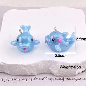 Macro view of blue iridescent dolphin pendants for DIY jewelry with dimensions and weight