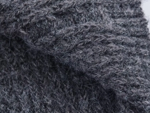 Makroaufnahme von dunkelgrauem Strick mit weicher Mohair-Textur und dicken Fasern