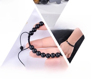 Detailed macro view of 8mm black onyx and tiger eye beaded bracelet with a cross charm