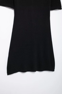 Close-up of black knit sleeveless dress showing fabric texture and hemline details