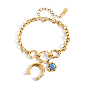 Detail of 18K gold stainless steel chain bracelet with blue resin horseshoe pendant